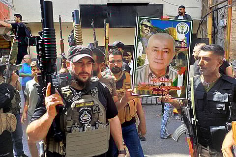 Israeli drone strike in Lebanon: Palestinian Fatah fighters from Al-Aqsa Martyrs' Brigades, carry a portrait of Khalil al-Maqdah